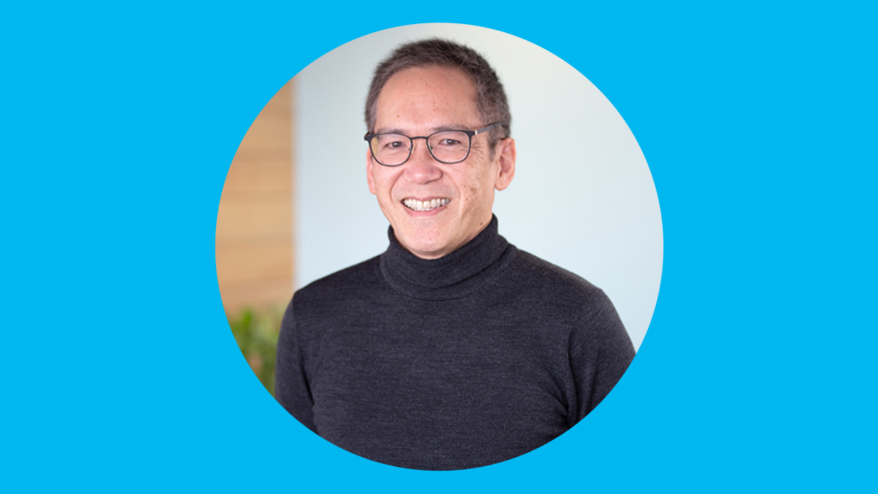 Photo of Dr. Liu smiling wearing glasses and a black turtleneck sweater