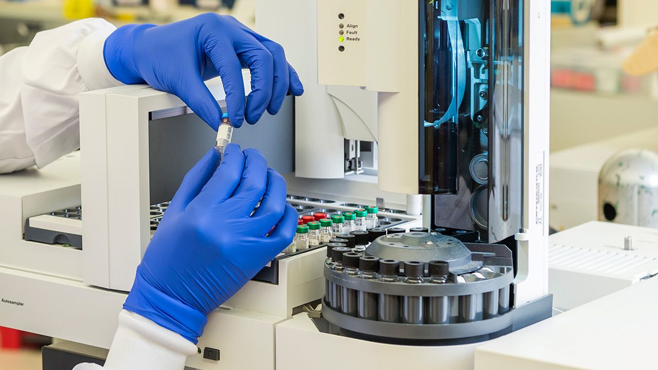 Scientist using an analytical machine in a laboratory