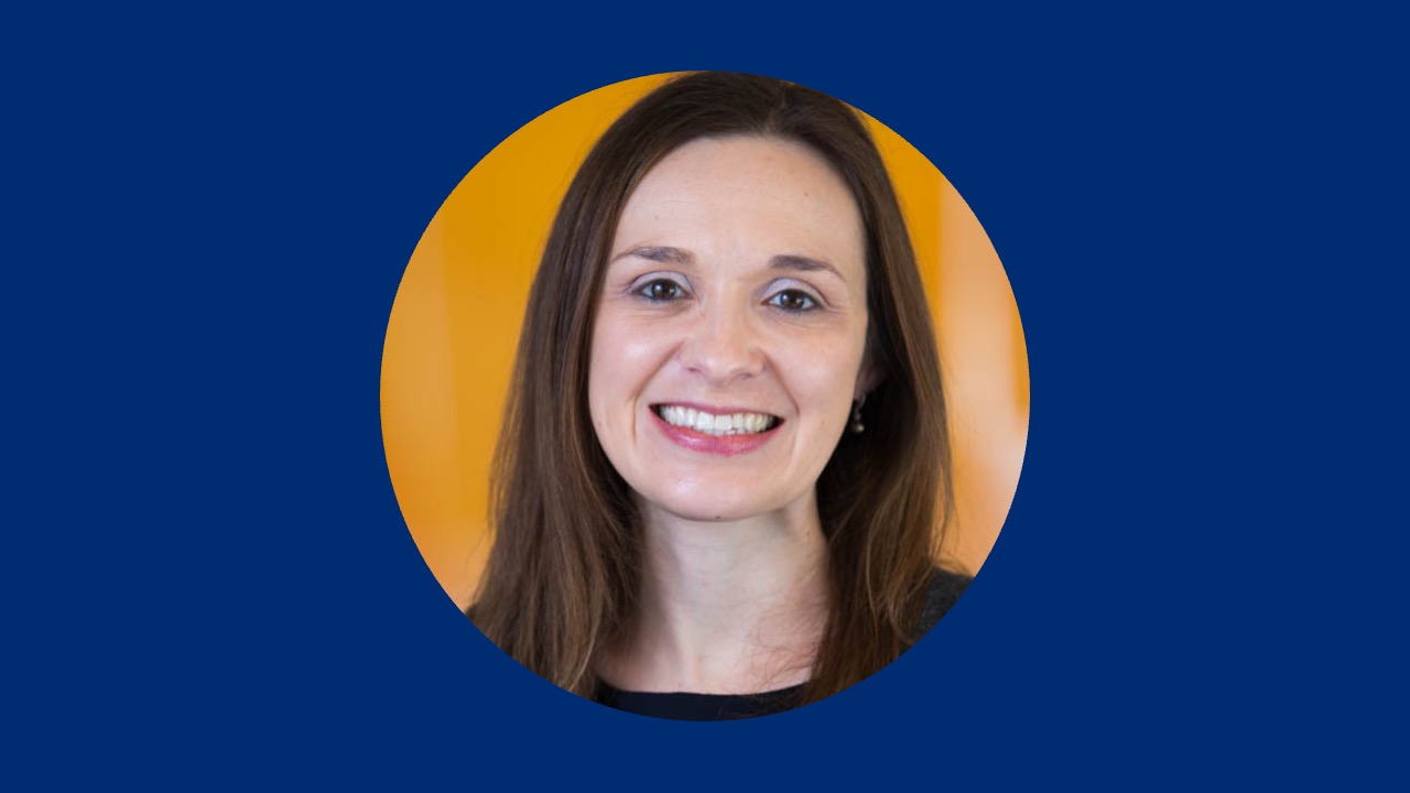 Professional headshot of Alyssa Schlenz, PhD, centered in a circular crop, with a solid dark blue background.