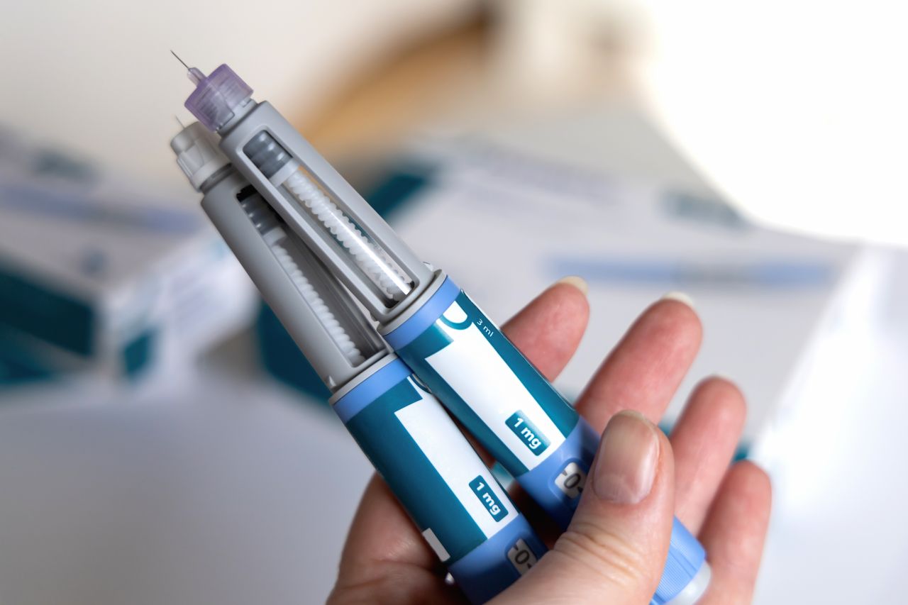 Hand holding auto-injectors with medication