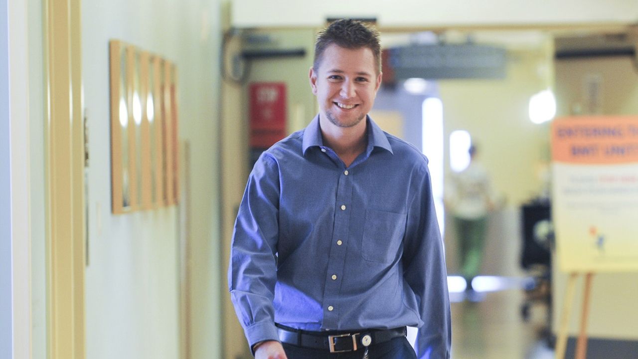 A doctor walks through the hospital smiling. 
