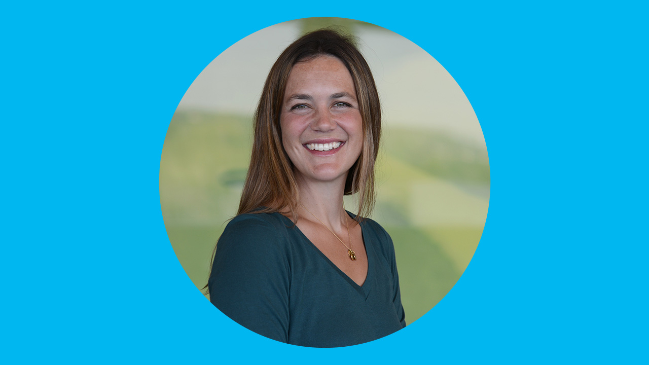 Headshot of Ashley Rogers, MD, on a blue background.