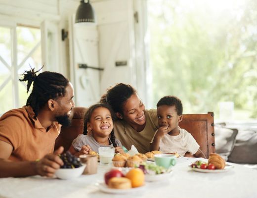 Family gathered around a table eating a meal together.