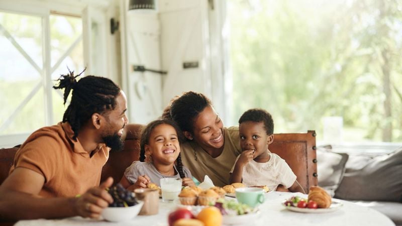 Family gathered around a table eating a meal together.