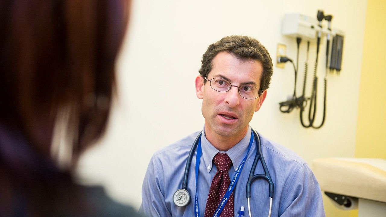 Doctor with stethoscope around his neck talking to a patient