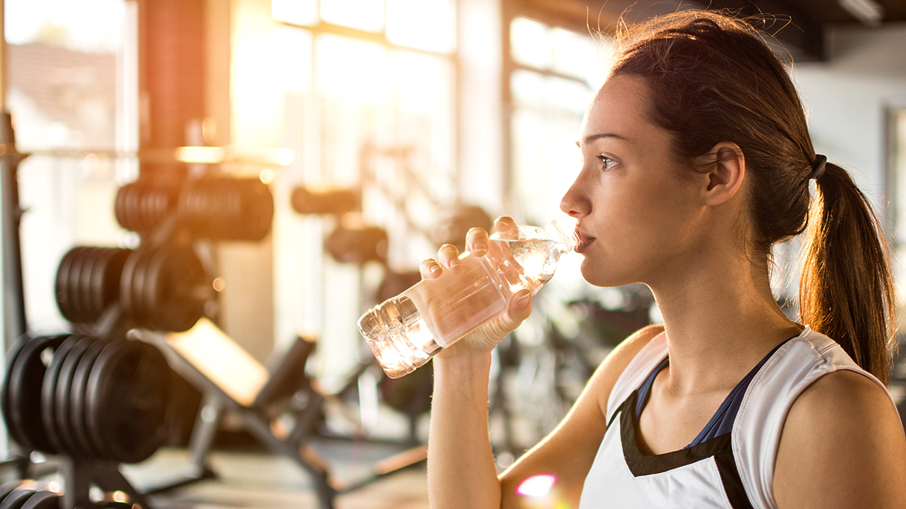 Girl drinking water at a gym