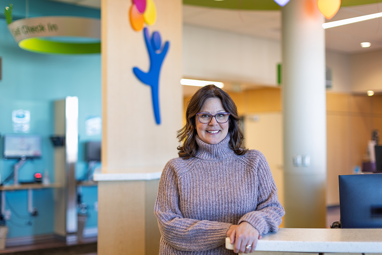 Heather Siemers, Guest Relations Lead standing at check-in counter 