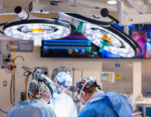 Surgeons performing surgery in an operating room with equipment.