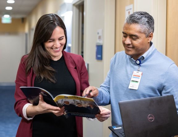 Two team members look at a brochure