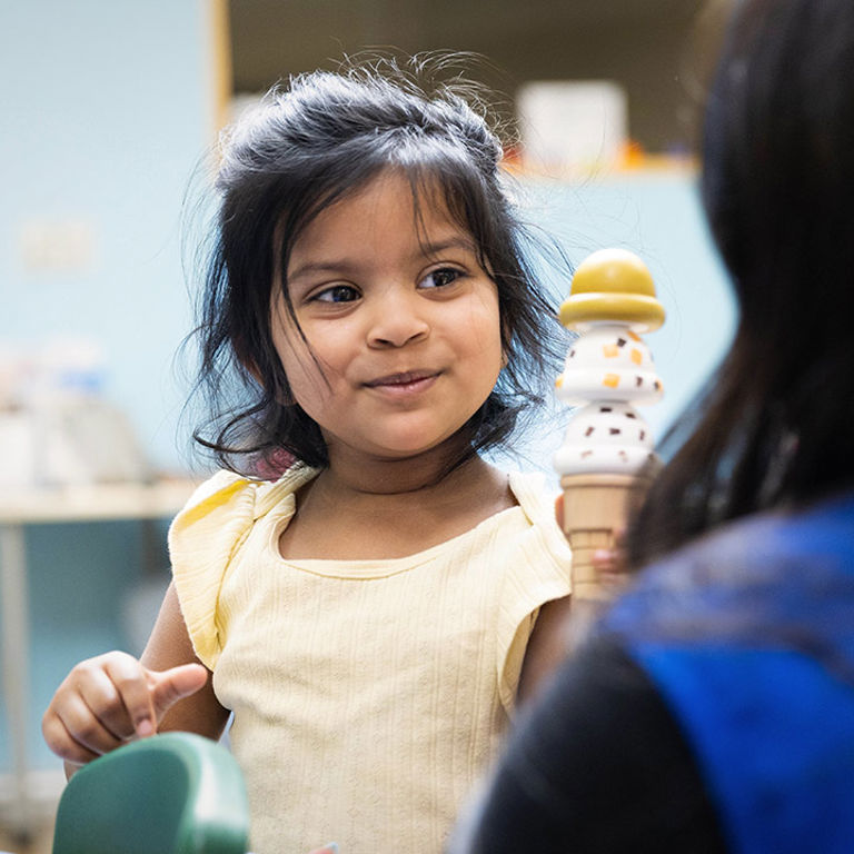 Young girl plays with toy ice cream cone
