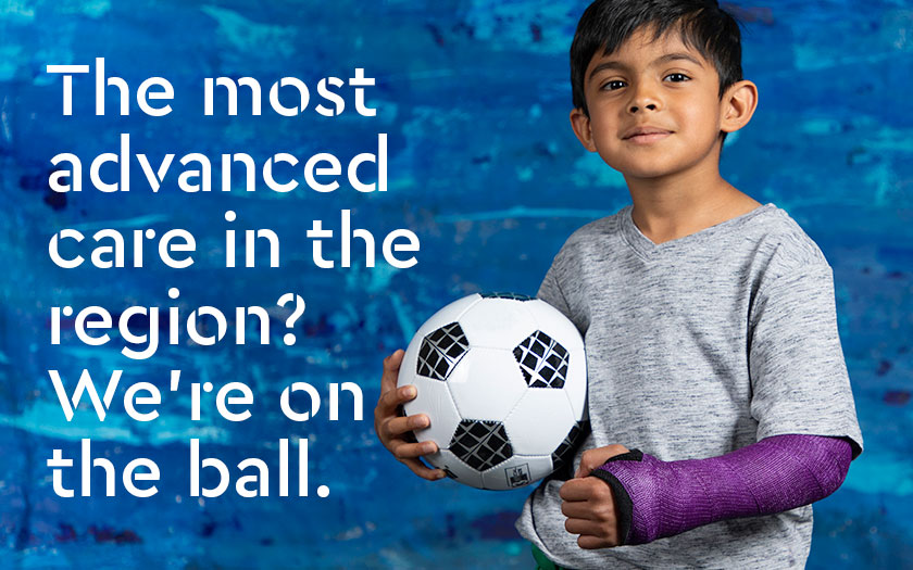 Nikhil holding a soccer ball.