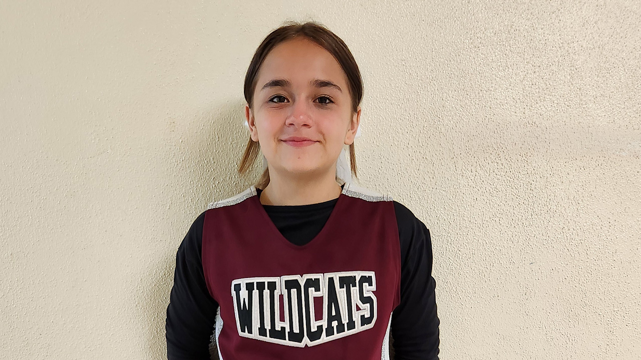 Jaycee smiles in her Wildcats cheerleading uniform.