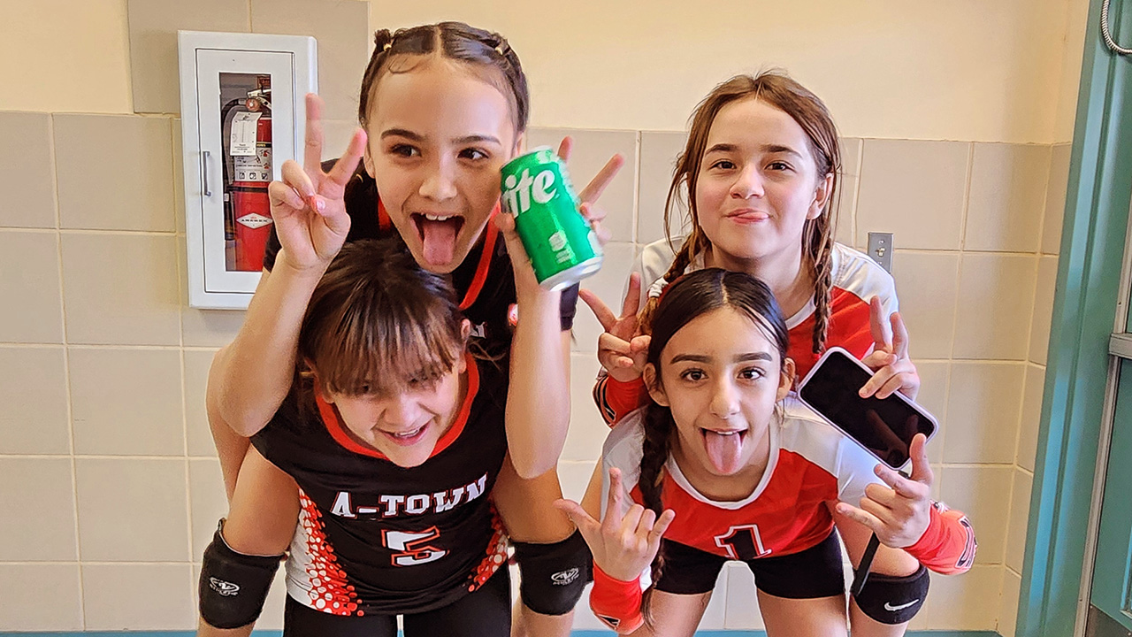 Jaycee goofs around with three of her friends after volleyball practice in their volleyball uniforms.
