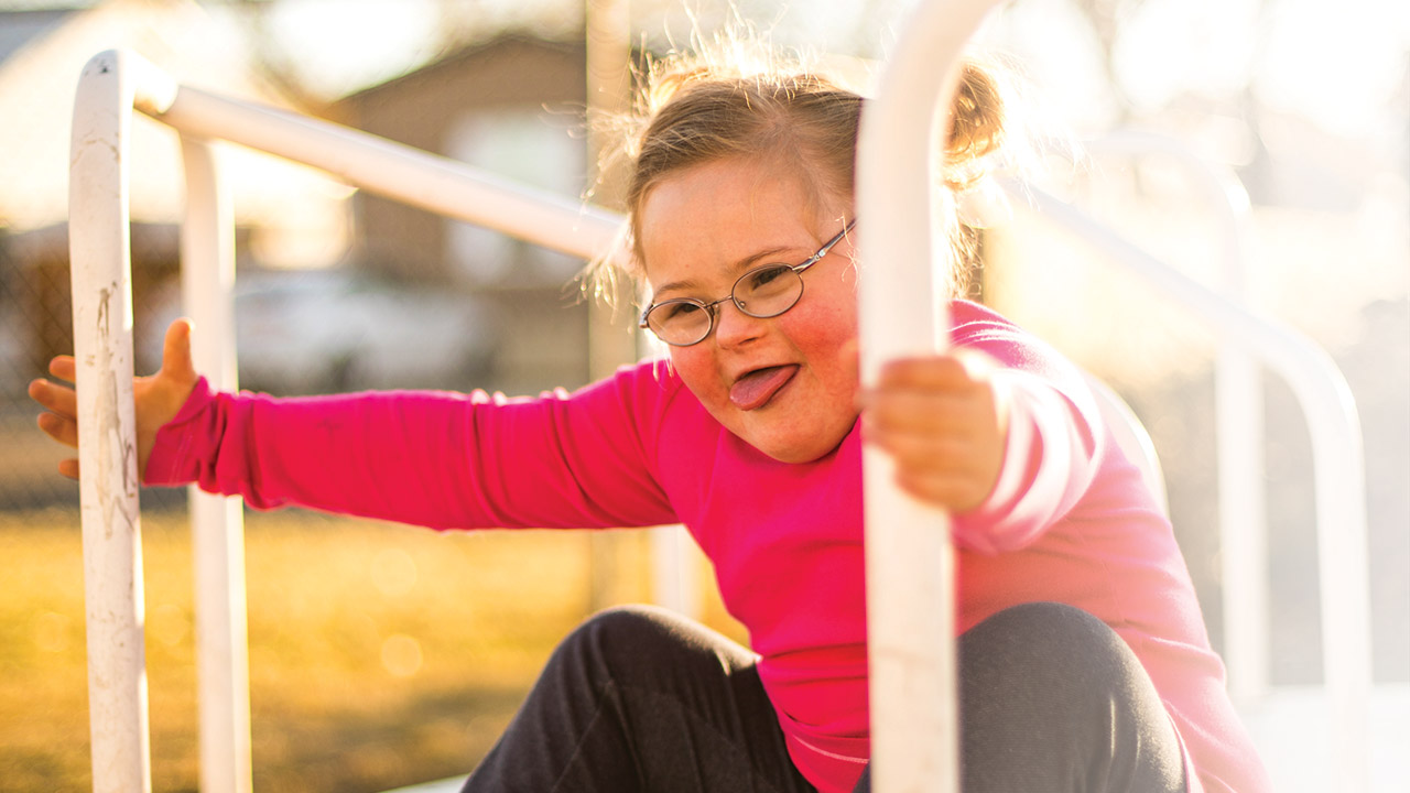 Maddie, a patient of the Sie Center, plays on a playground.