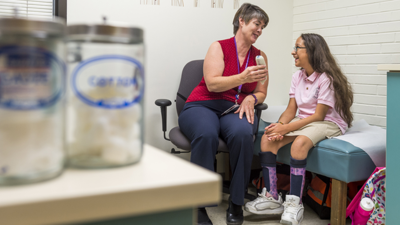 A school nurse helps a student at school. 