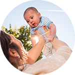 A mom holds up her baby