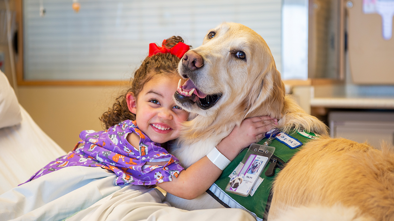 Wellness Program A child hugs a therapy dog