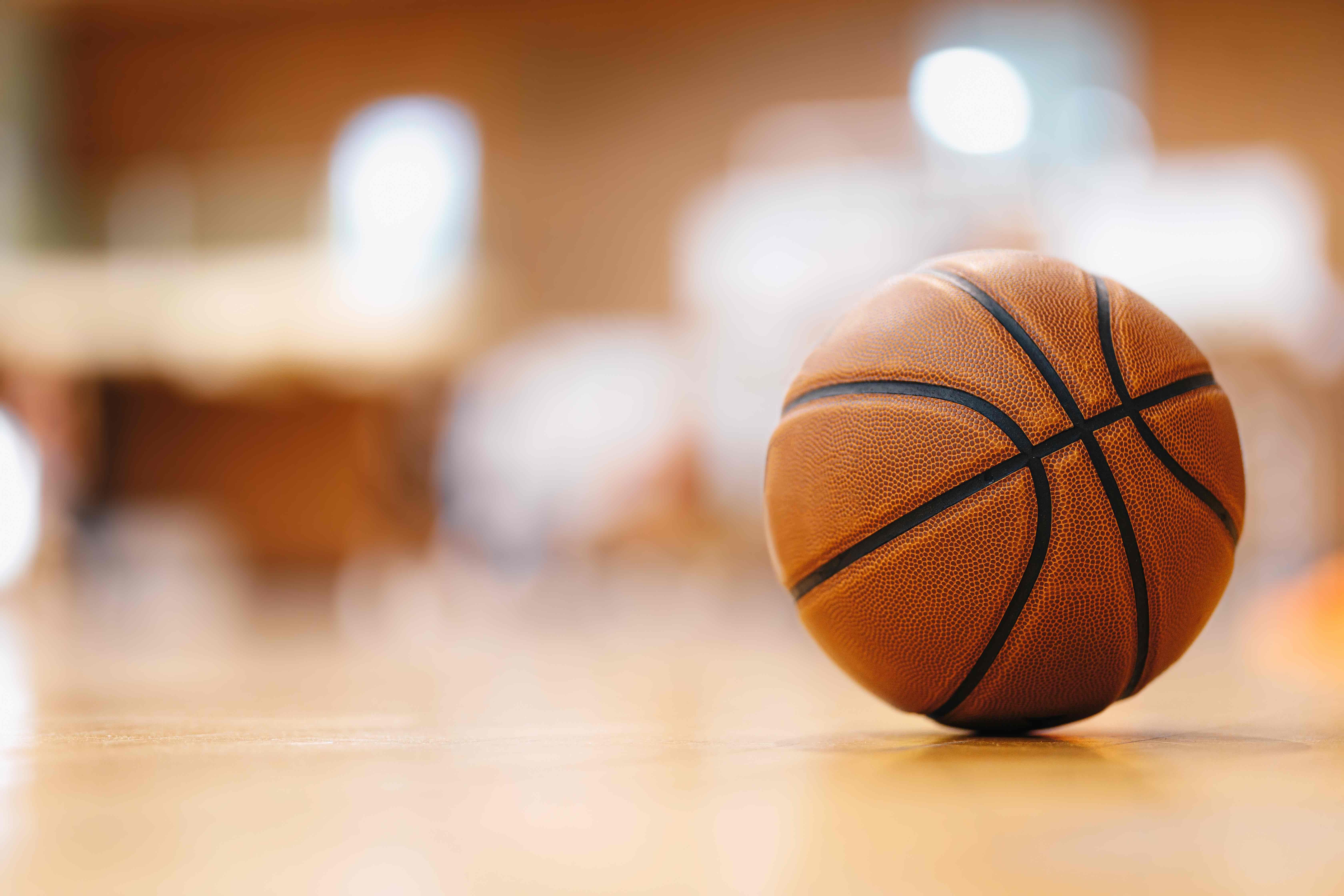 A basketball resting on a gym floor