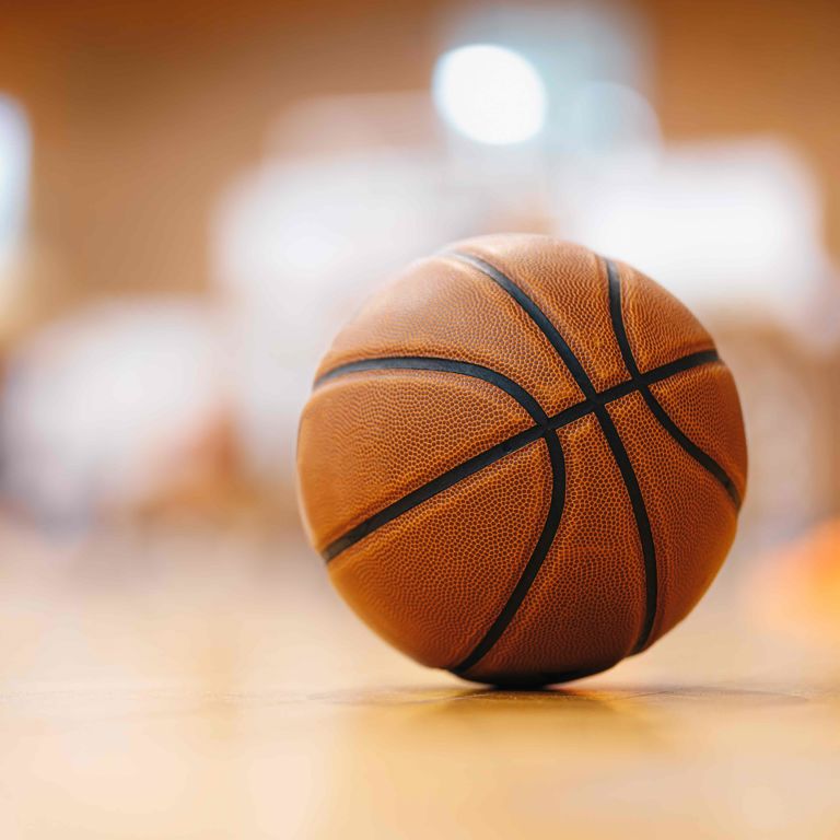 A basketball resting on a gym floor