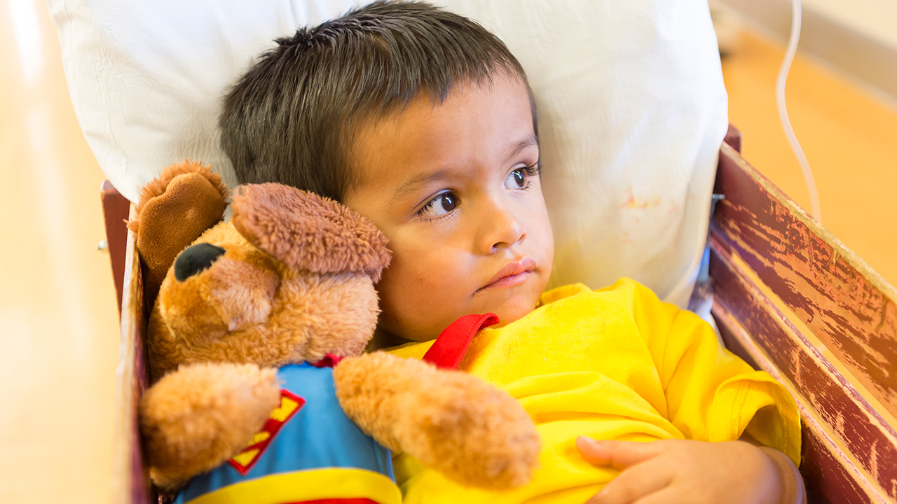 Neuroscience Conditions We Treat A young boy sits in a red wagon hugging a stuffed animal