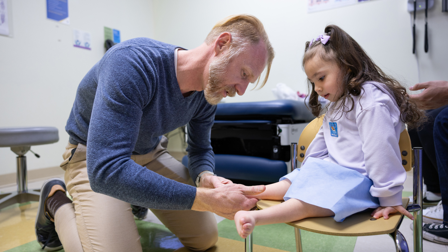 Person examining a child's leg 