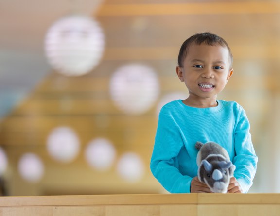 Child smiling holding a stuff animal