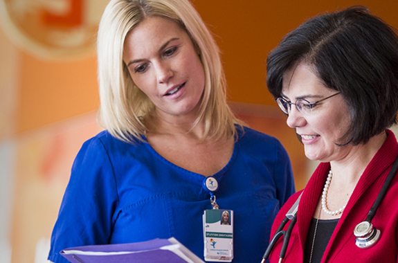 Two women healthcare professionals looking at a medical chart.