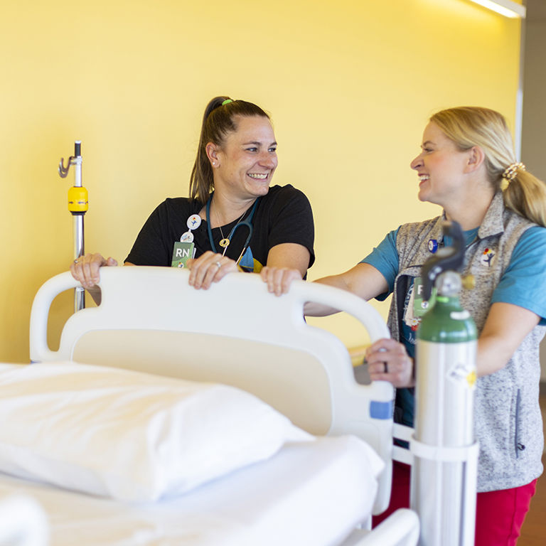 A close-up of a nurse’s hands providing gentle care to a pediatric patient.