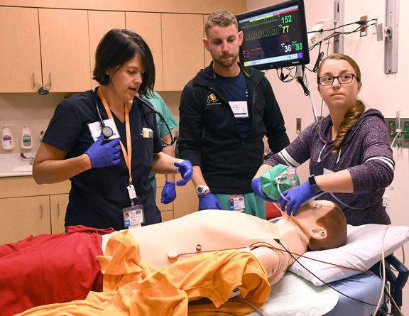 A clinical team performing a life-saving resuscitation drill on a patient simulator.