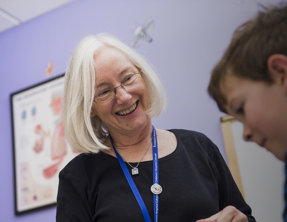 A doctor smiles at a boy in an exam room