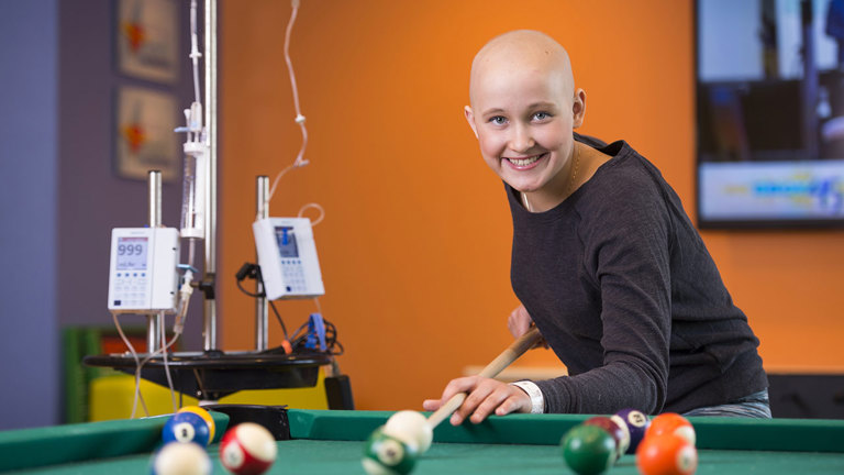 Patient playing pool in Children’s Colorado’s Teen Zone