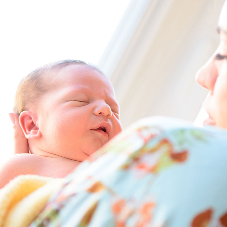 Mother with her baby in a white room.