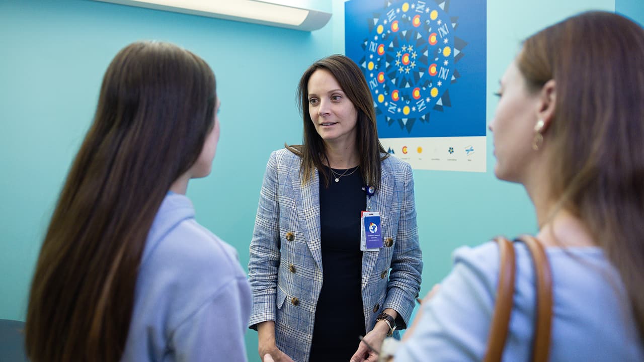 Dr. Tricia Huguelet speaks with a patient and her mother at Children’s Hospital Colorado. 