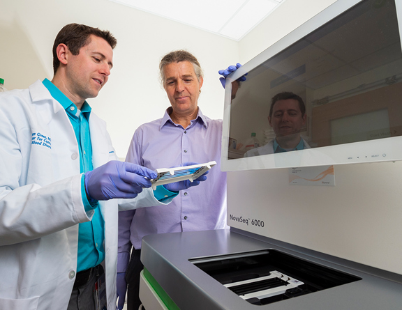 Doctors looking at a lab machine used for radiation-induced gliomas