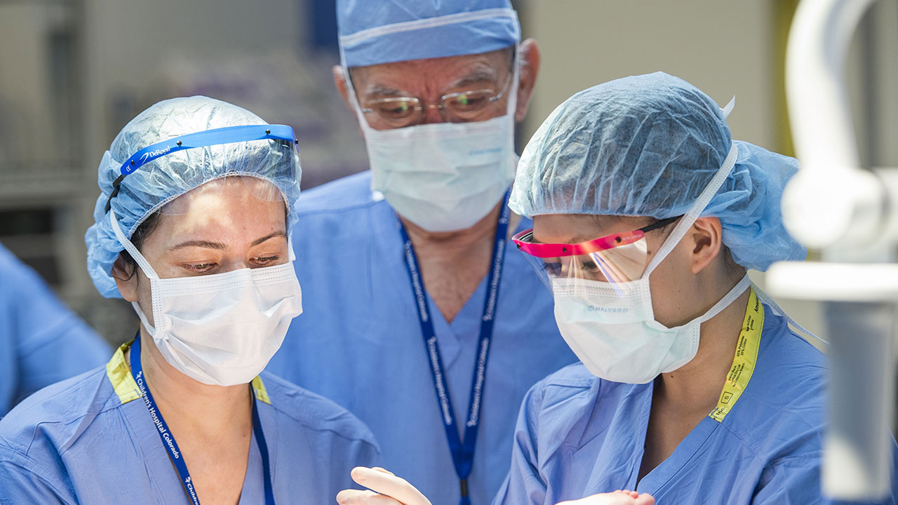 Three doctors work together in surgery.