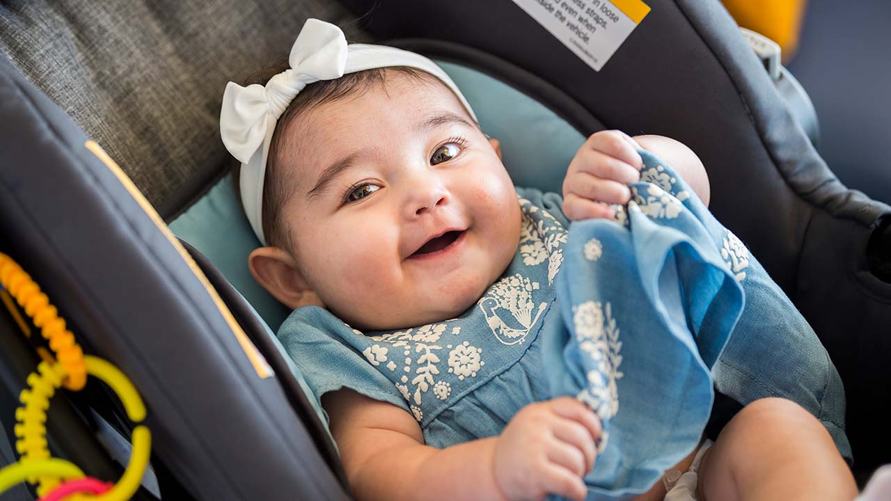 Baby girl smiling in the car.