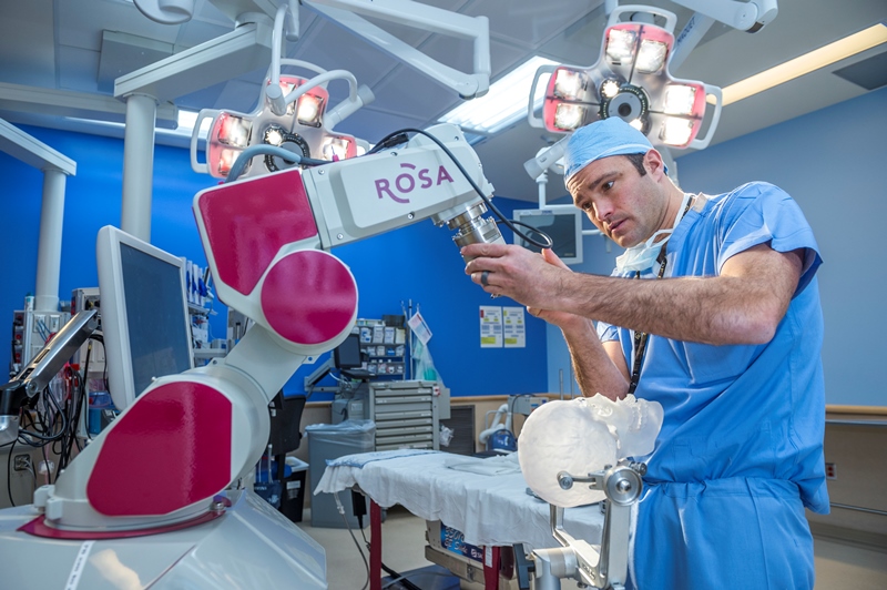 Dr. Brent O'Neill uses ROSA the Robot.