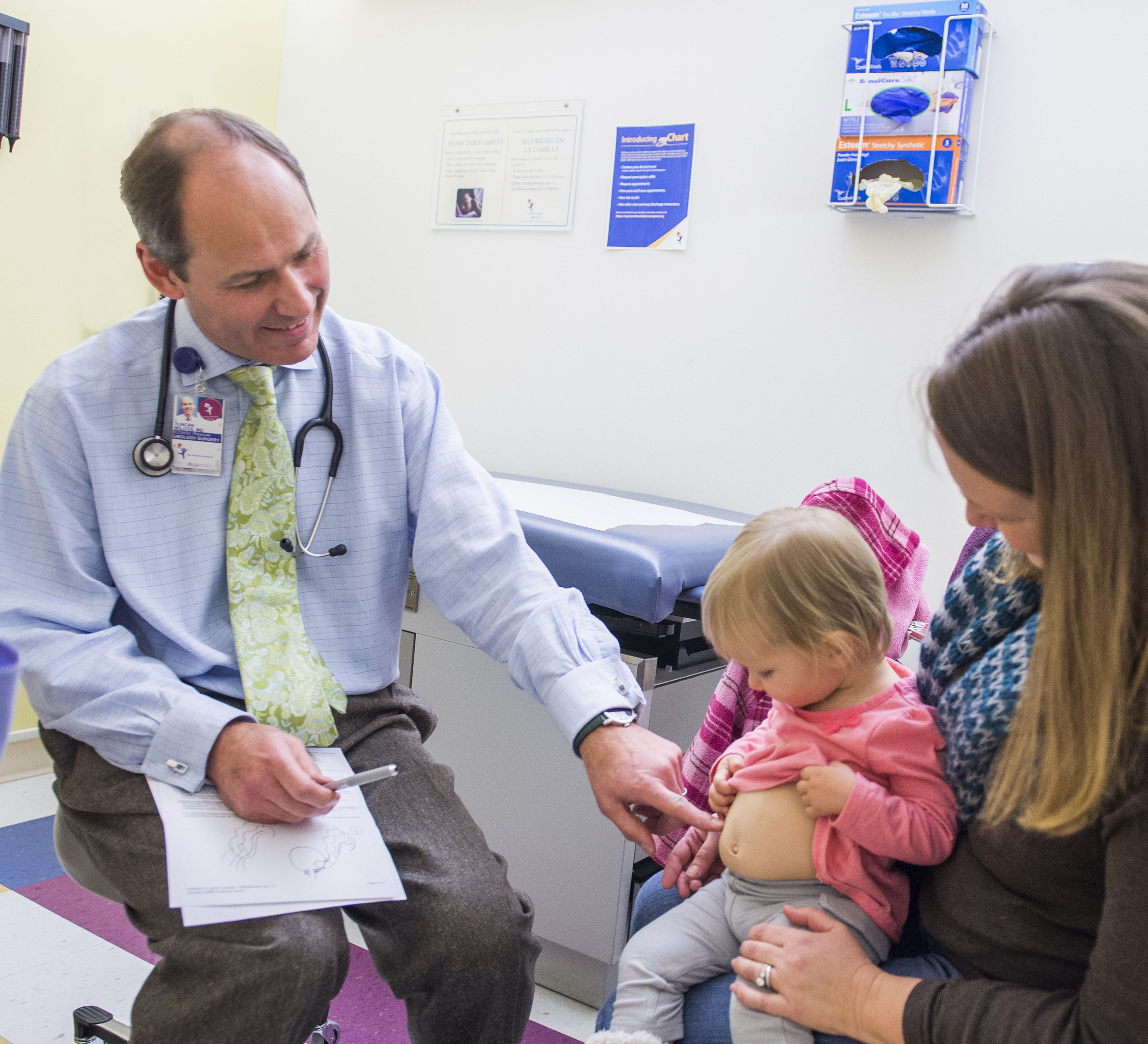 A urologists examines a girl's stomach.