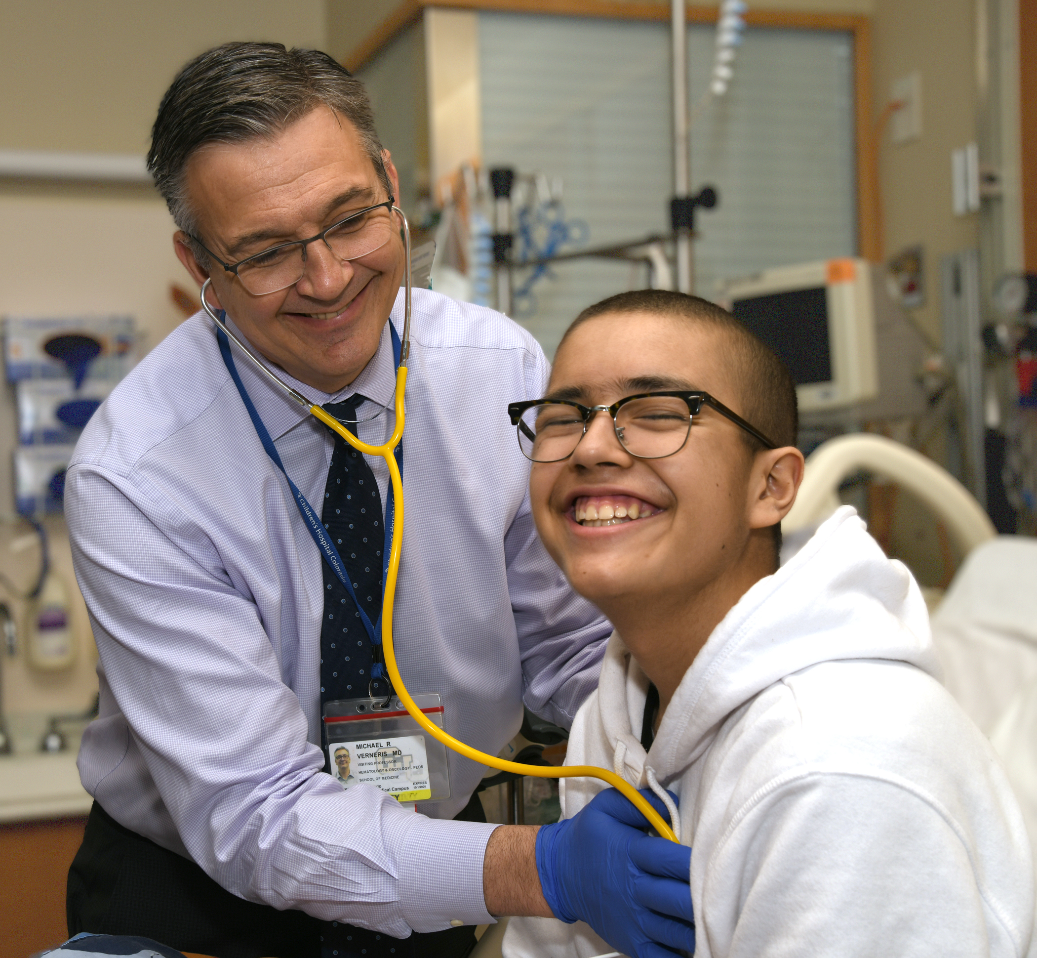 A doctor listens to the heartbeat of a boy.