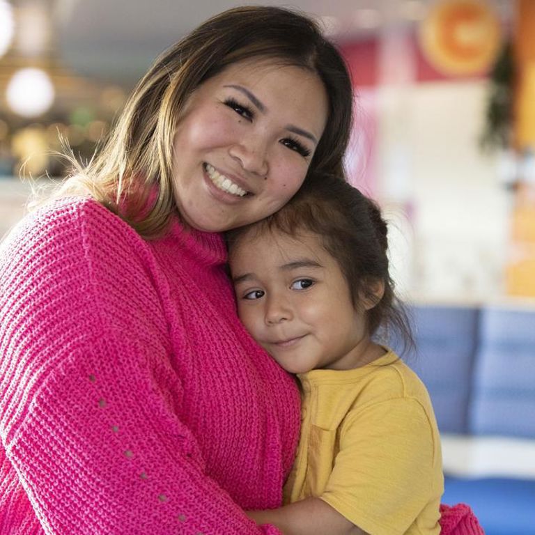 A parent embraces a child in the waiting room of a healthcare facility.